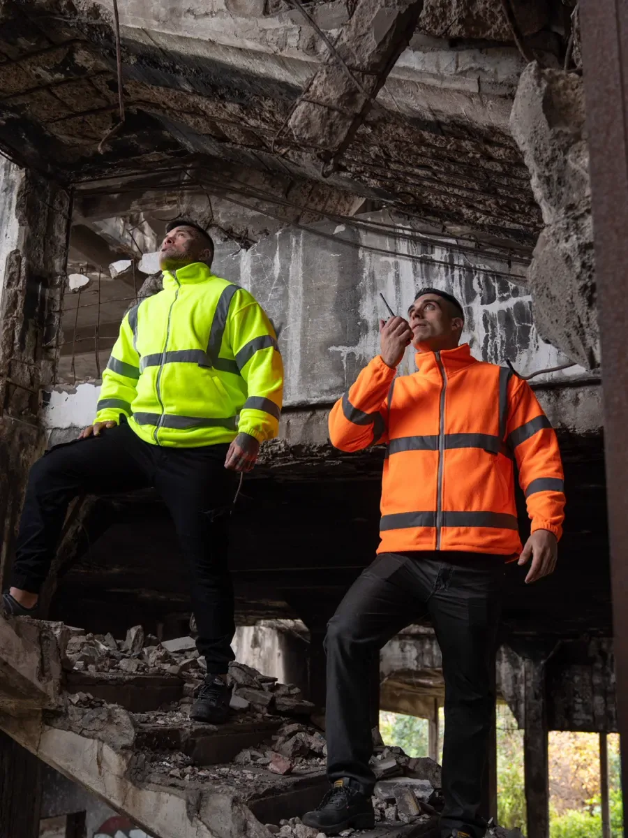 Zwei Handwerker in Warnschutzjacken auf der Baustelle
